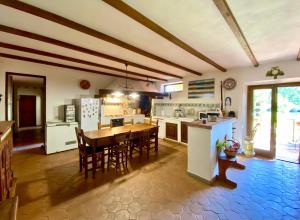 una cucina con un tavolo e sedie in una stanza di La casa di Francesco Incantevole casale di campagna with pool piscina a Soriano nel Cimino Altre 44 foto