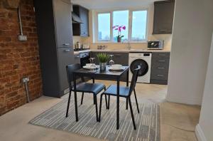 Una cocina con una mesa y sillas en una cocina. en Stylish City Centre Apartment with Parking, en Preston
