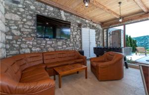 a living room with leather furniture and a stone wall at Lovely Home In Bribir in Bribir +42 photos