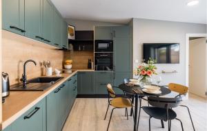 a kitchen with green cabinets and a table and chairs at Beautiful Home In Privlaka in Privlaka