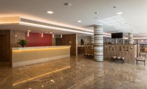 a lobby with a waiting room with stools at Sleep Inn Praia do Canto in Vitória