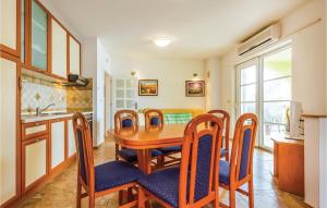 kuchnia i jadalnia z drewnianym stołem i krzesłami w obiekcie 2 Bedroom Awesome Apartment In Banjol w mieście Banjol