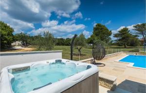 een hot tub op een patio naast een zwembad bij Villa Emanuel in Pula