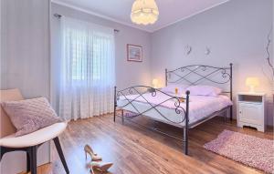 een slaapkamer met een roze bed en een stoel bij Villa Emanuel in Pula