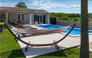 een hangmat op een patio naast een zwembad bij Villa Pepi in Pulići