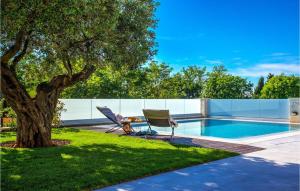 un patio con 2 sedie e un albero accanto alla piscina di Villa Vista Savudrija a Umag (Umago)