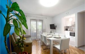 ein Esszimmer und eine Küche mit einem weißen Tisch und Stühlen in der Unterkunft Awesome Home In Zrnovnica With Kitchen in Žrnovnica