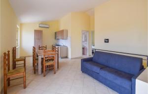 a living room with a blue couch and a kitchen at Amazing Home In Melito Porto Salvo in Melito di Porto Salvo +13 photos