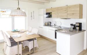 Una cocina con gabinetes blancos y una mesa de madera. en Beautiful Home In Büsum With Kitchen, en Büsum
