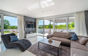 a living room with a couch and chairs and windows at Villa Evoque in Bibinje