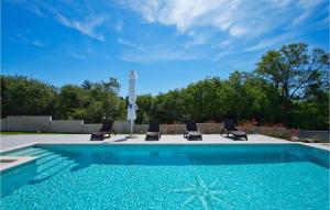 een zwembad met een groep stoelen ernaast bij Villa Windrose in Pula