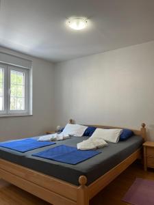 een slaapkamer met een bed met blauwe lakens en een raam bij Apartments KARLO in Baška Voda +32 foto's
