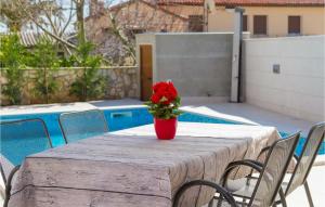 a table with a vase with a red flower on it at Villa Miceli in Pula