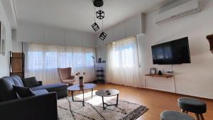 a living room with a couch and a tv at Antonia's city apartment in Ioannina
