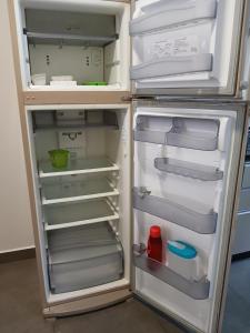 an empty refrigerator with its door open in a kitchen at Iguassu Falls Refuge - Cataratas do Iguassu - Paraguai - Argentina in Foz do Iguaçu