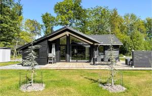 a black house with a porch and some trees at Amazing Home In Hasle With Wifi in Hasle