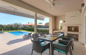 a patio with a table and chairs and a swimming pool at Villa Suprema Premantura in Pula