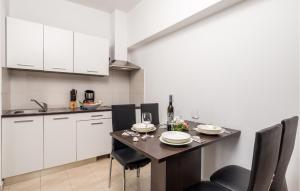 a kitchen with a table and chairs and white cabinets at 1 Bedroom Awesome Apartment In Vrh in Vrh +31 photos