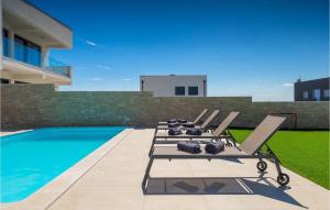 une rangée de chaises longues à côté d'une piscine dans l'établissement Villa Elena Rovinj, à Rovinj