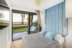 a bedroom with a bed and a large window at Apartament Holiday Gold in Rewal +69 photos