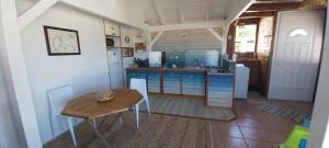 a kitchen with a wooden table and a tableasteryasteryasteryasteryasteryasteryastery at La cabane du pêcheur in Le Gosier
