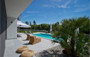 een zwembad met rieten stoelen naast een huis bij Villa Windrose in Pula +52 foto's