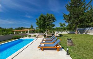 een groep ligstoelen naast een zwembad bij Villa Pepi in Pulići