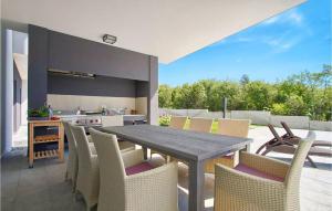 een eetkamer met een houten tafel en stoelen bij Villa Windrose in Pula