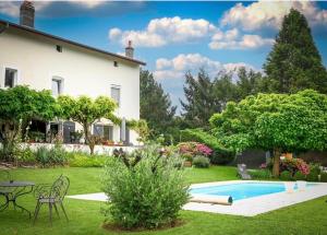 a garden with a house and a swimming pool at LA MAISON D INÈS and UGOLIN & SPA in Baccarat