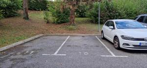 a white car parked in a parking lot at Agréable chambre in Prévessin-Moëns
