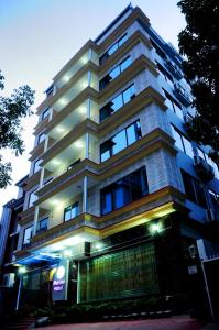 un edificio alto con luces encendidas delante de él en Marino Hotel - Best near Airport, en Dhaka