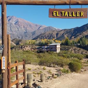 a sign that reads el taller with mountains in the background at Cabaña La Mostacita - Complejo El Taller in Potrerillos