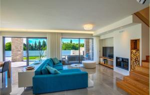 un soggiorno con un divano blu e una TV di Villa Vista Savudrija a Umag (Umago)