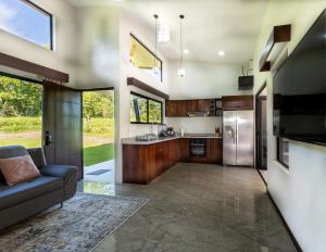 an open kitchen with stainless steel appliances and a couch at Oro Verde Lodge in Fortuna