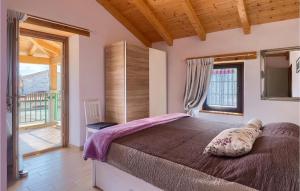 a bedroom with a large bed and a balcony at Villa Ive in Orbanići