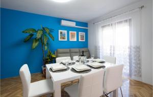 ein Esszimmer mit einem weißen Tisch und weißen Stühlen in der Unterkunft Awesome Home In Zrnovnica With Kitchen in Žrnovnica