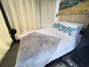 a small bedroom with a white bed with pillows at Arkansas Mirror House in Conway