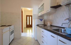 La cuisine blanche est équipée d'un évier et d'un réfrigérateur. dans l'établissement Nice Apartment In Racisce With Wifi, à Račišće
