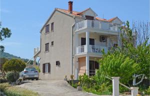 une maison blanche avec une voiture garée devant elle dans l'établissement Nice Apartment In Racisce With Wifi, à Račišće