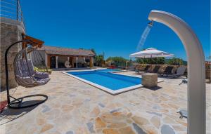 a swimming pool with a swing and a swing at Villa Kunta in Zadar