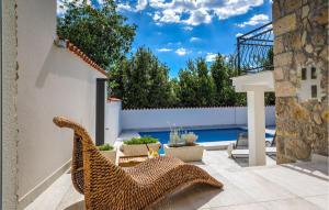 un patio con una sedia in vimini e una piscina di Villa Vele Skale a Jadranovo