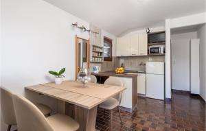 eine Küche mit einem Holztisch und weißen Geräten in der Unterkunft Lovely Apartment In Rab With Kitchen in Rab