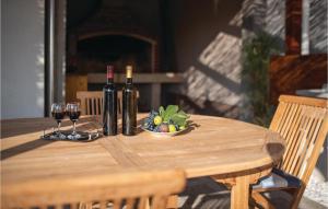 a wooden table with wine bottles and a bowl of fruit at Amazing Home In Oklaj With Wifi in Oklaj