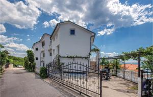 ein weißes Haus mit einem Tor davor in der Unterkunft Awesome Apartment In Crikvenica in Crikvenica + 26 Fotos