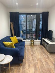 a living room with a blue couch and a tv at The Duplex at Sophia Mews with free parking in Cardiff