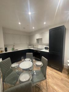 a kitchen with a table with four chairs and a black refrigerator at The Duplex at Sophia Mews with free parking in Cardiff