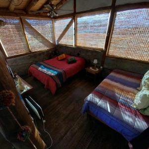 a bedroom with two beds in a room with windows at Cabaña La Mostacita - Complejo El Taller in Potrerillos