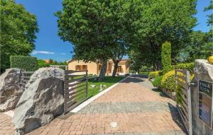 a fence with a tree and a house in the background at Villa Rosa Labin in Labin