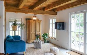 a living room with a blue chair and windows at Awesome Home In Warendorf With Wifi in Warendorf