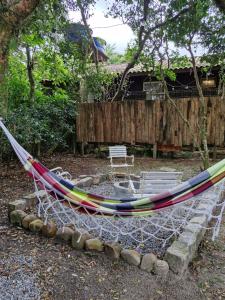 a hammock in a yard with a fire pit at Casinha Trilha da Guarda in Guarda do Embaú